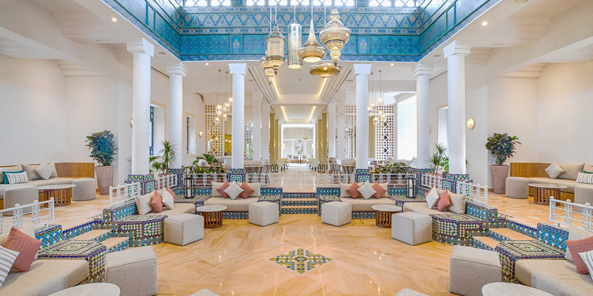 a large room with white columns and blue patterned furniture