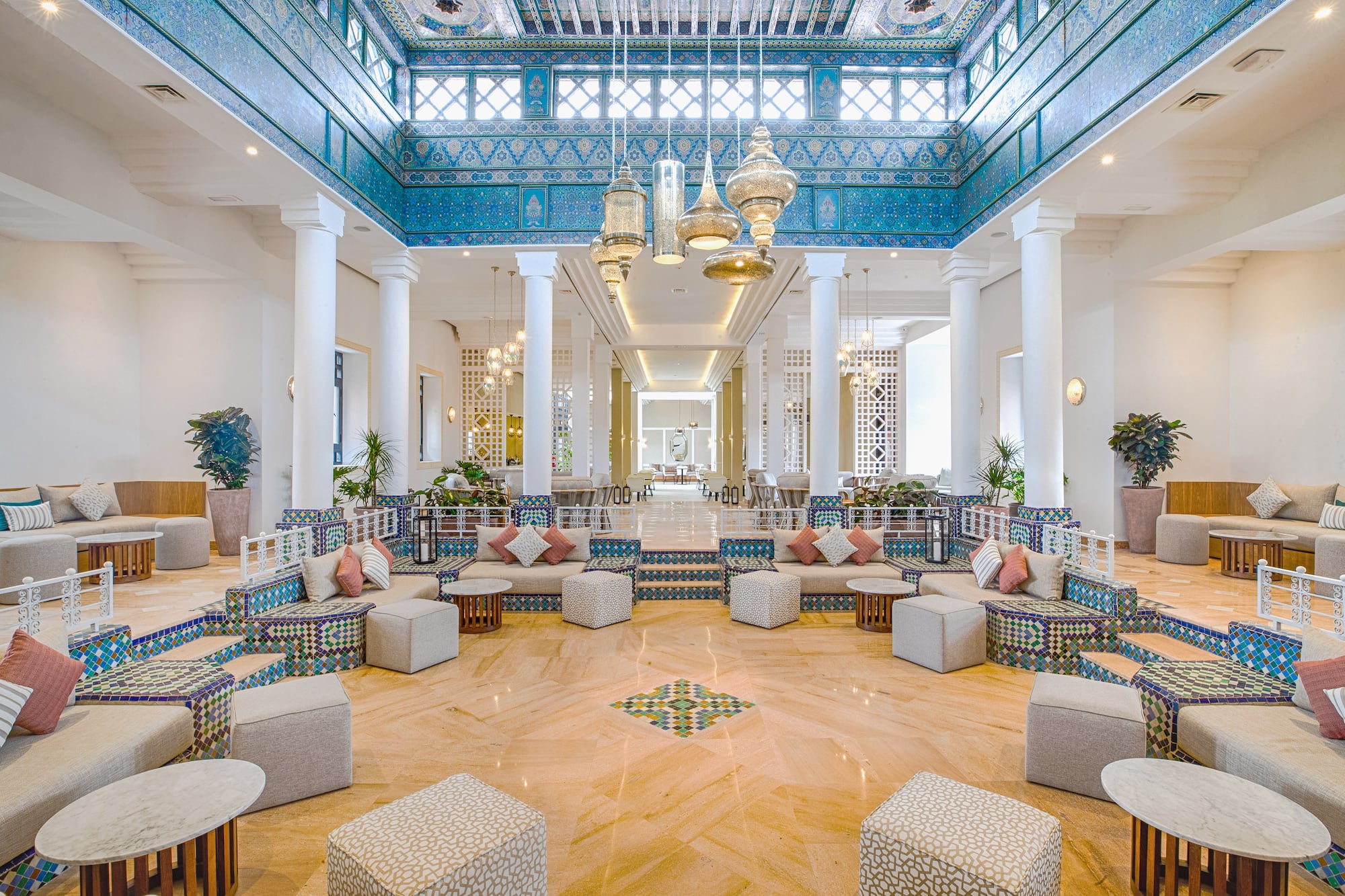 a large room with white columns and blue patterned furniture
