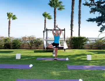 a woman standing on yoga mats in a yard