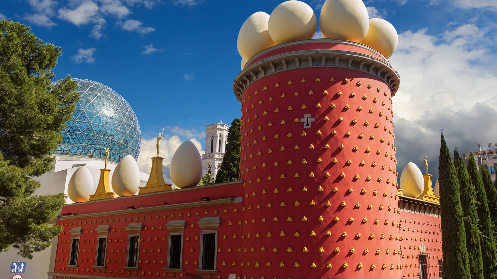 a building with a red tower with white eggs on top