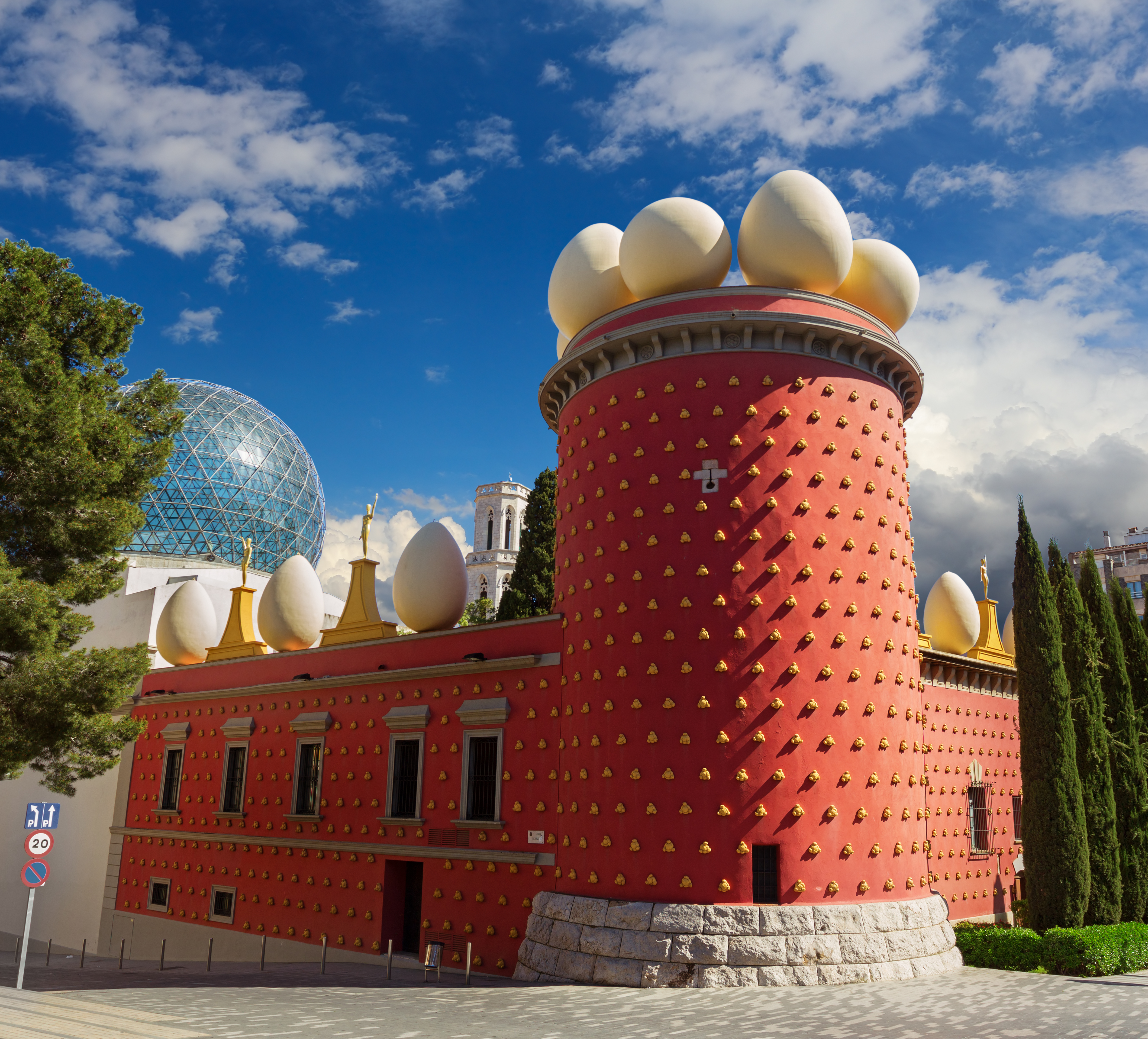 a building with a red tower with white eggs on top