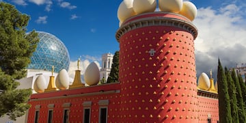 a building with a red tower with white eggs on top
