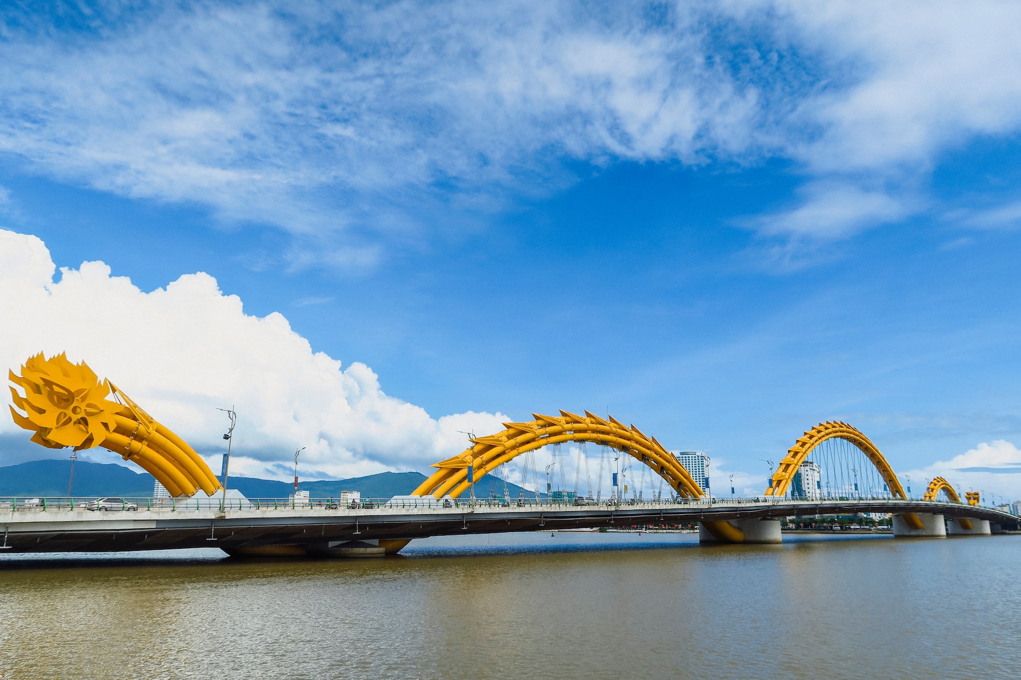 a bridge with a large yellow bridge over water