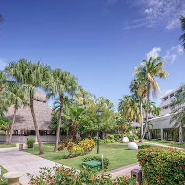 a building with palm trees and a grass roof