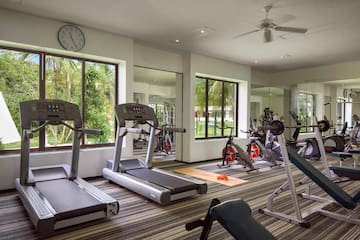 a room with exercise equipment and a clock