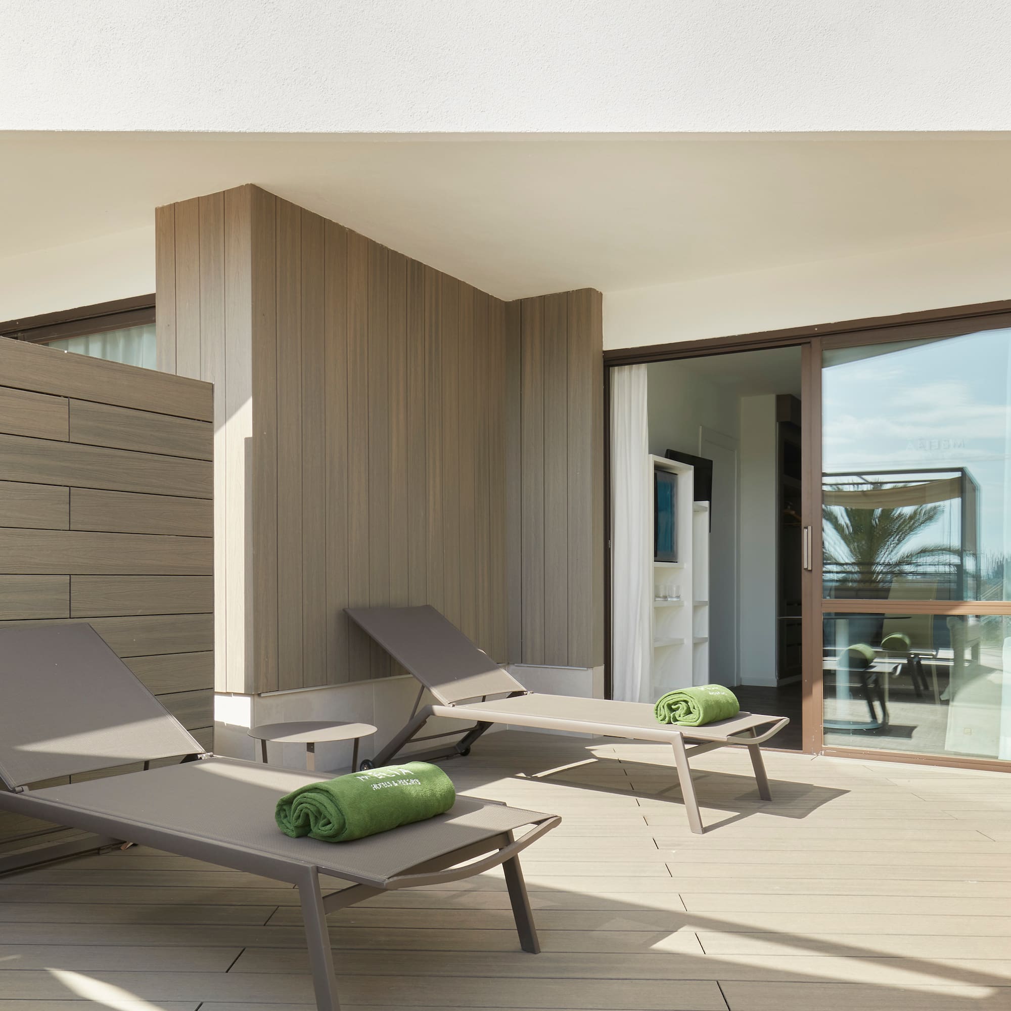 a deck with lounge chairs and towels on it