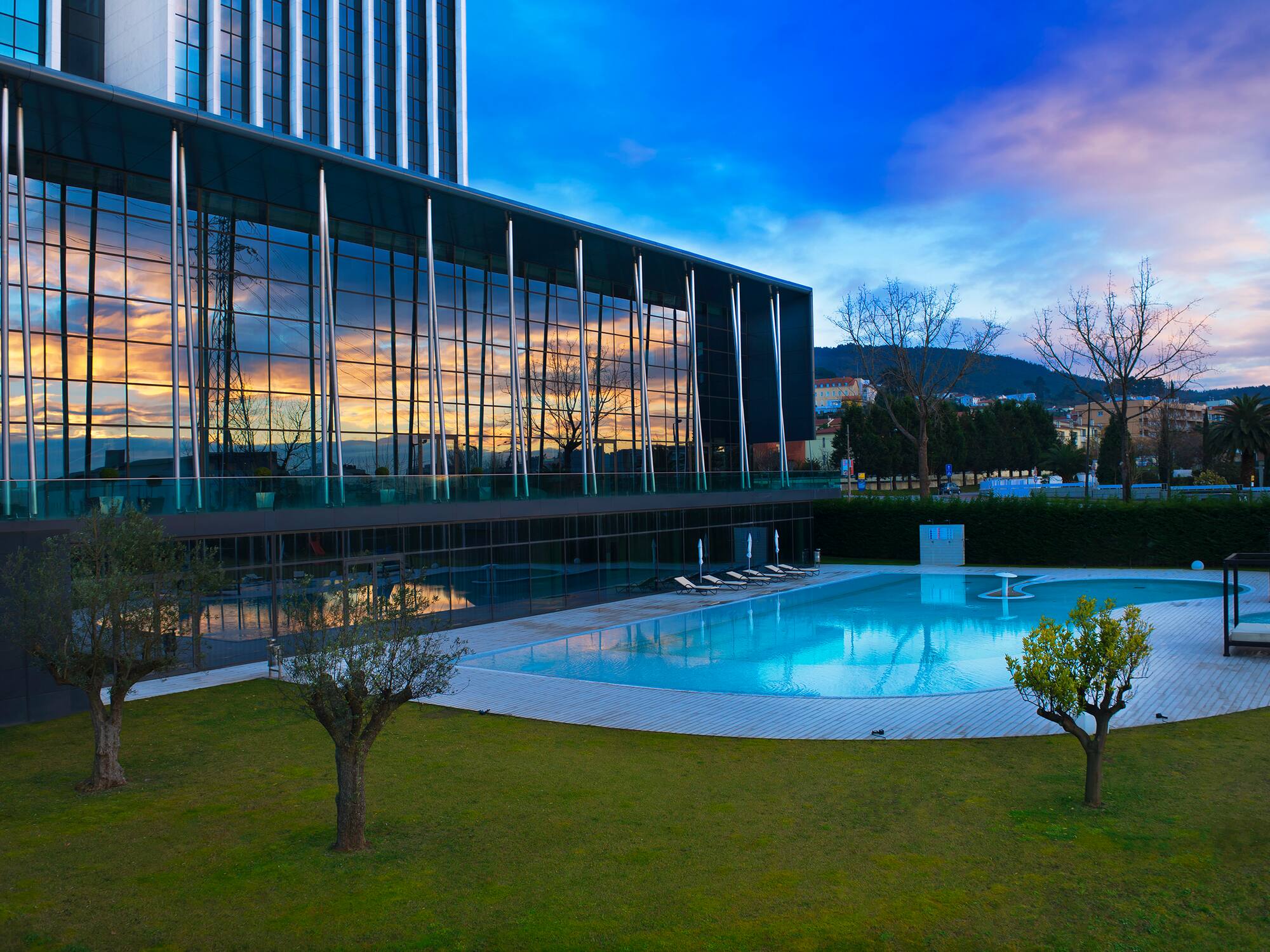 a building with a pool and trees