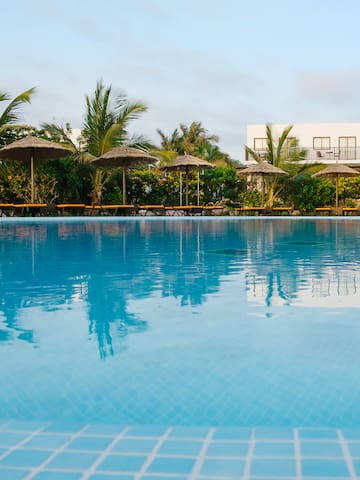 a pool with umbrellas and palm trees