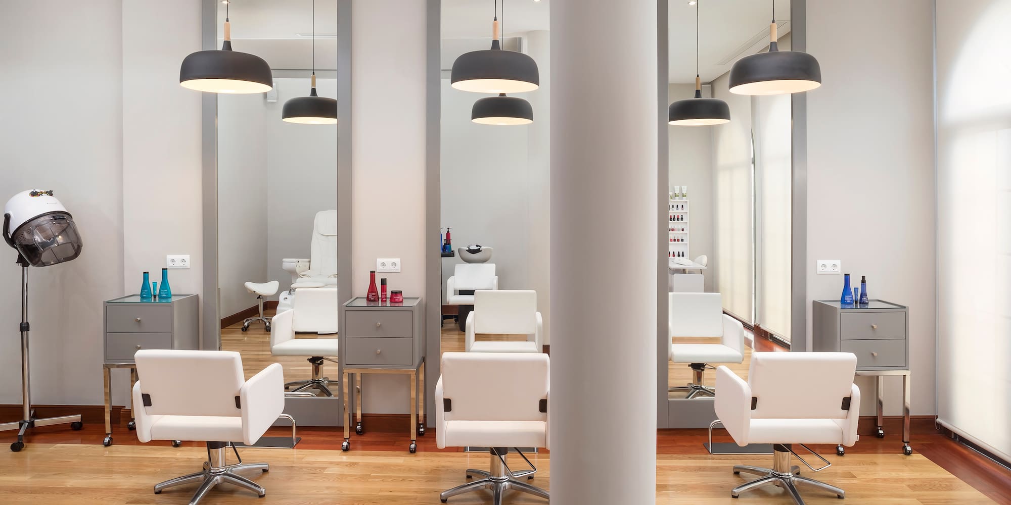 a room with white chairs and mirrors