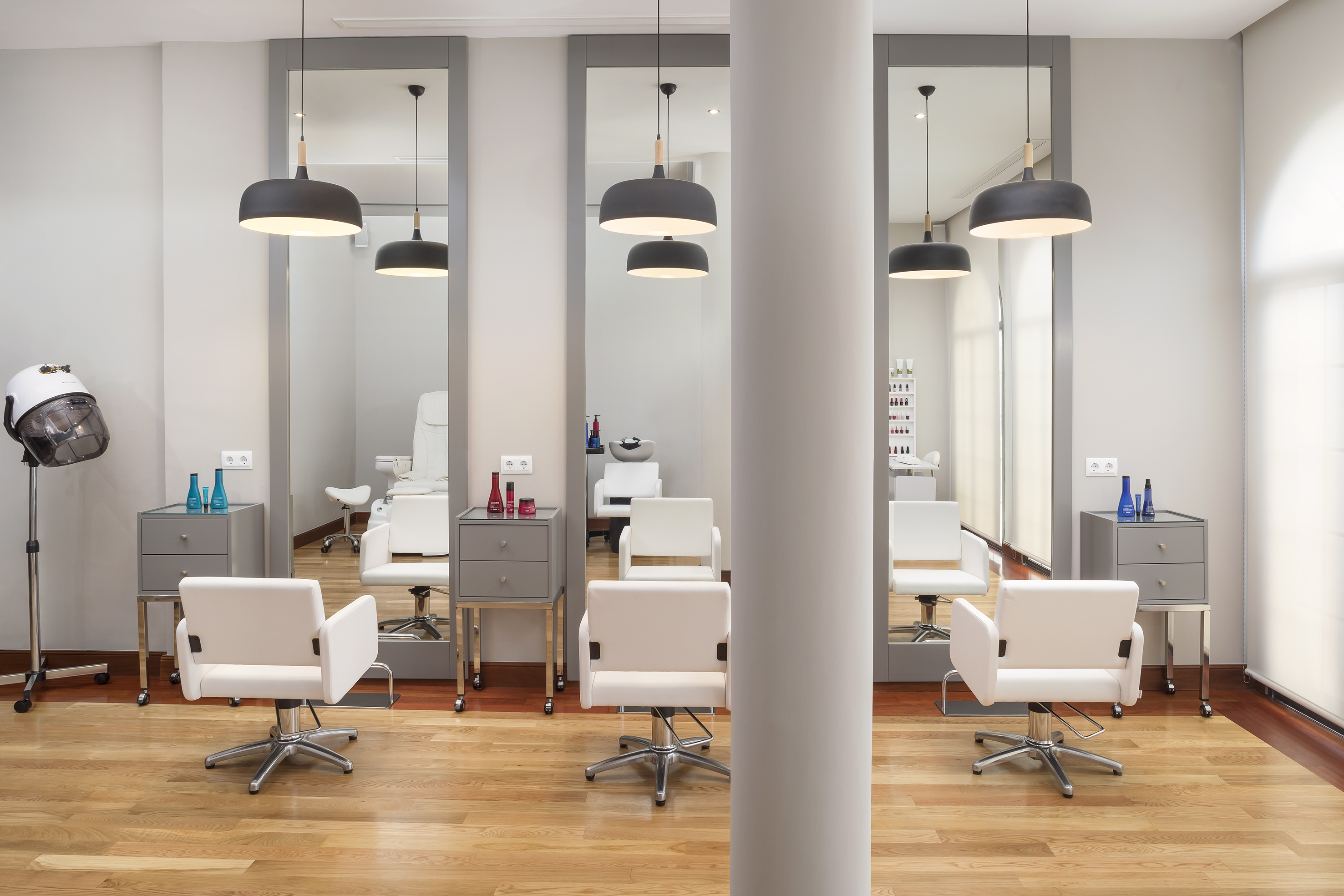 a room with white chairs and mirrors