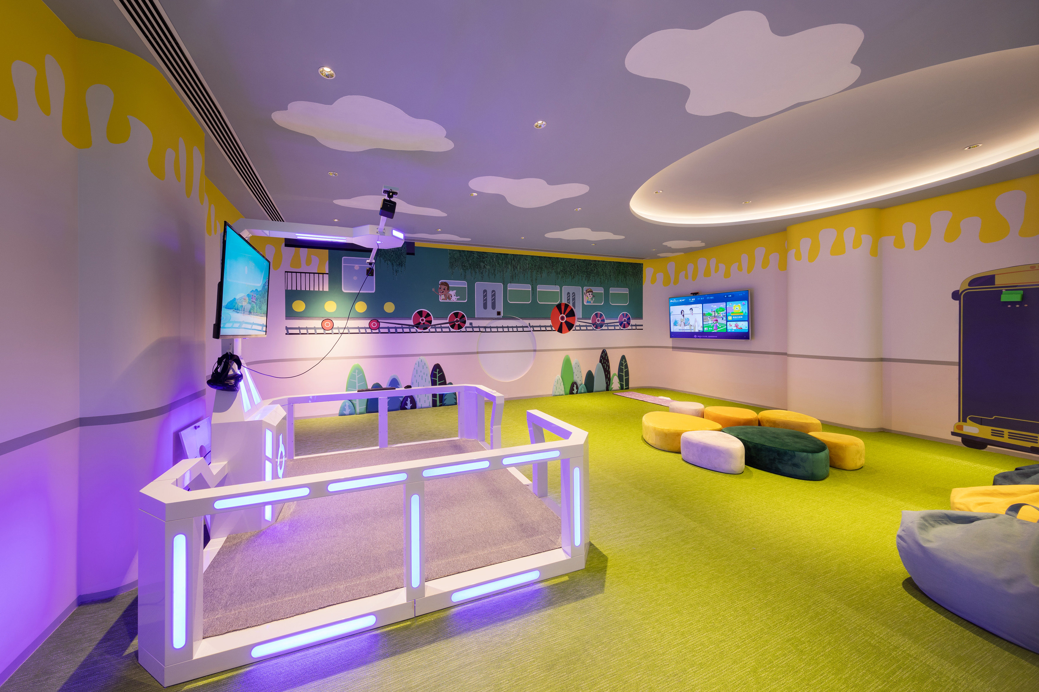 Kids club with train mural, interactive screens, and glowing play structure.