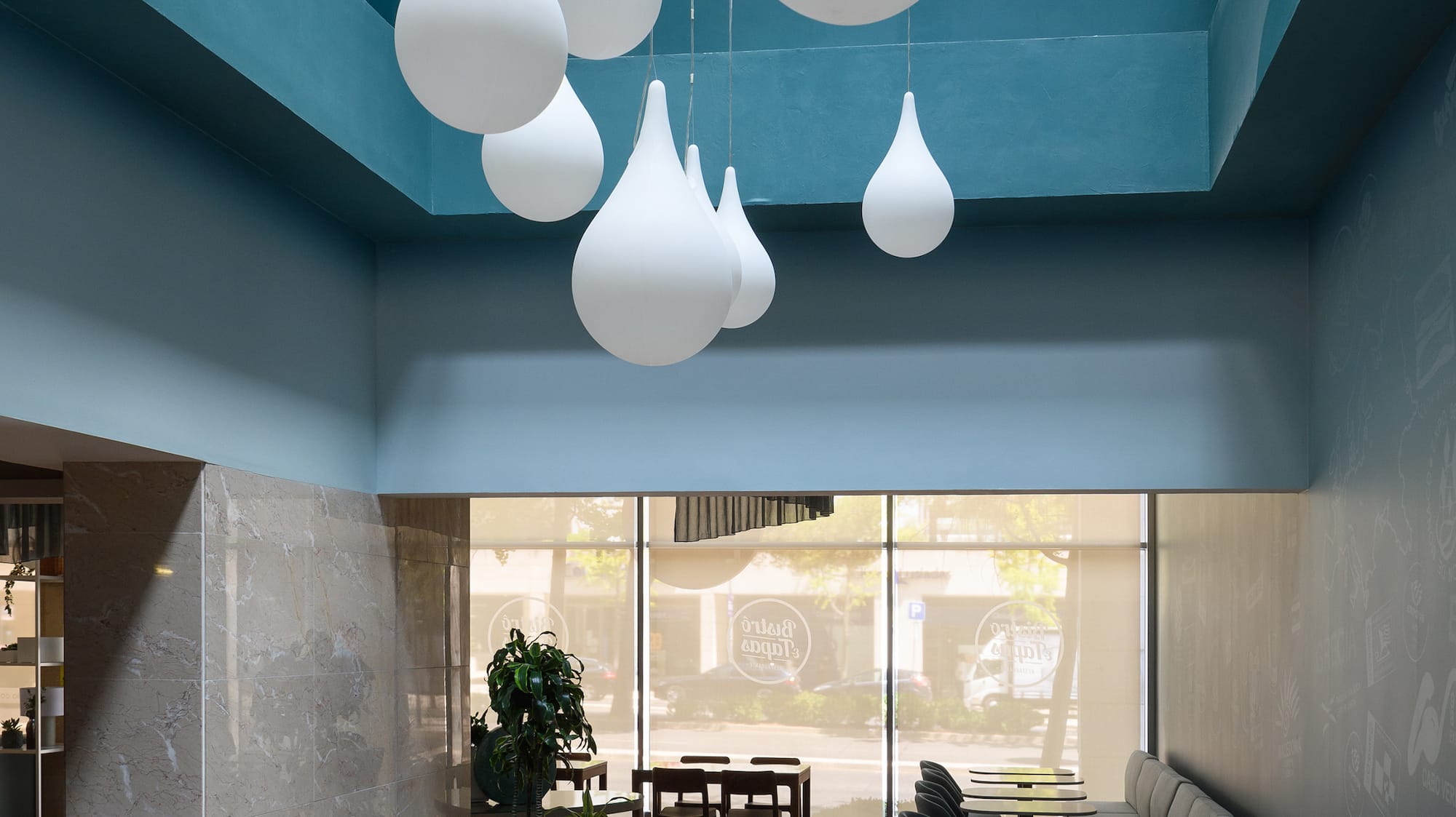 a room with tables and chairs and a blue ceiling