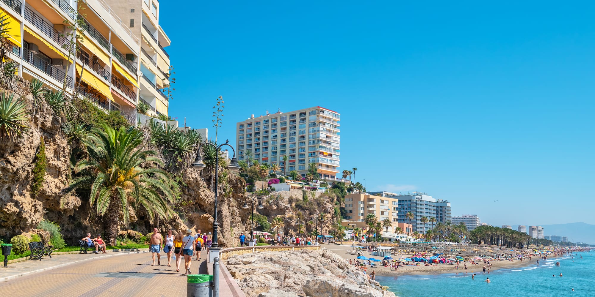 a group of people walking along a beach