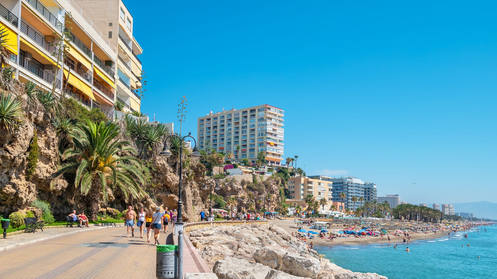 a group of people walking along a beach