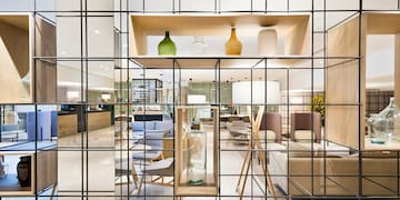 a glass wall with a shelf and a shelf with a chair and a table
