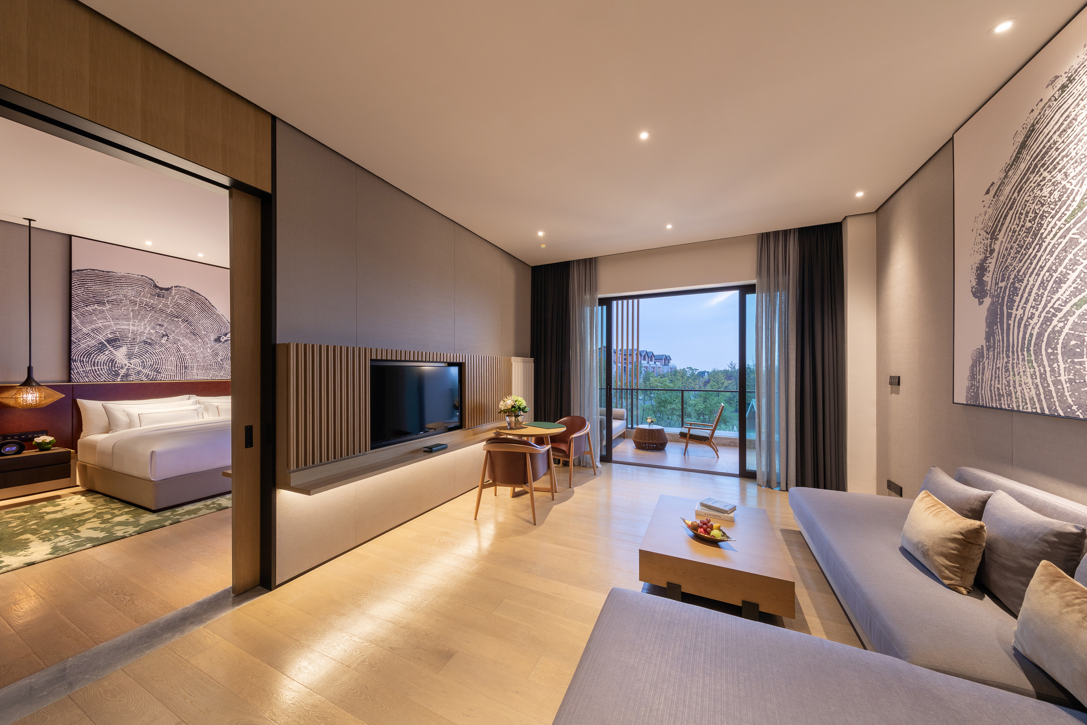 Modern luxury hotel suite with living area, bedroom, and balcony.