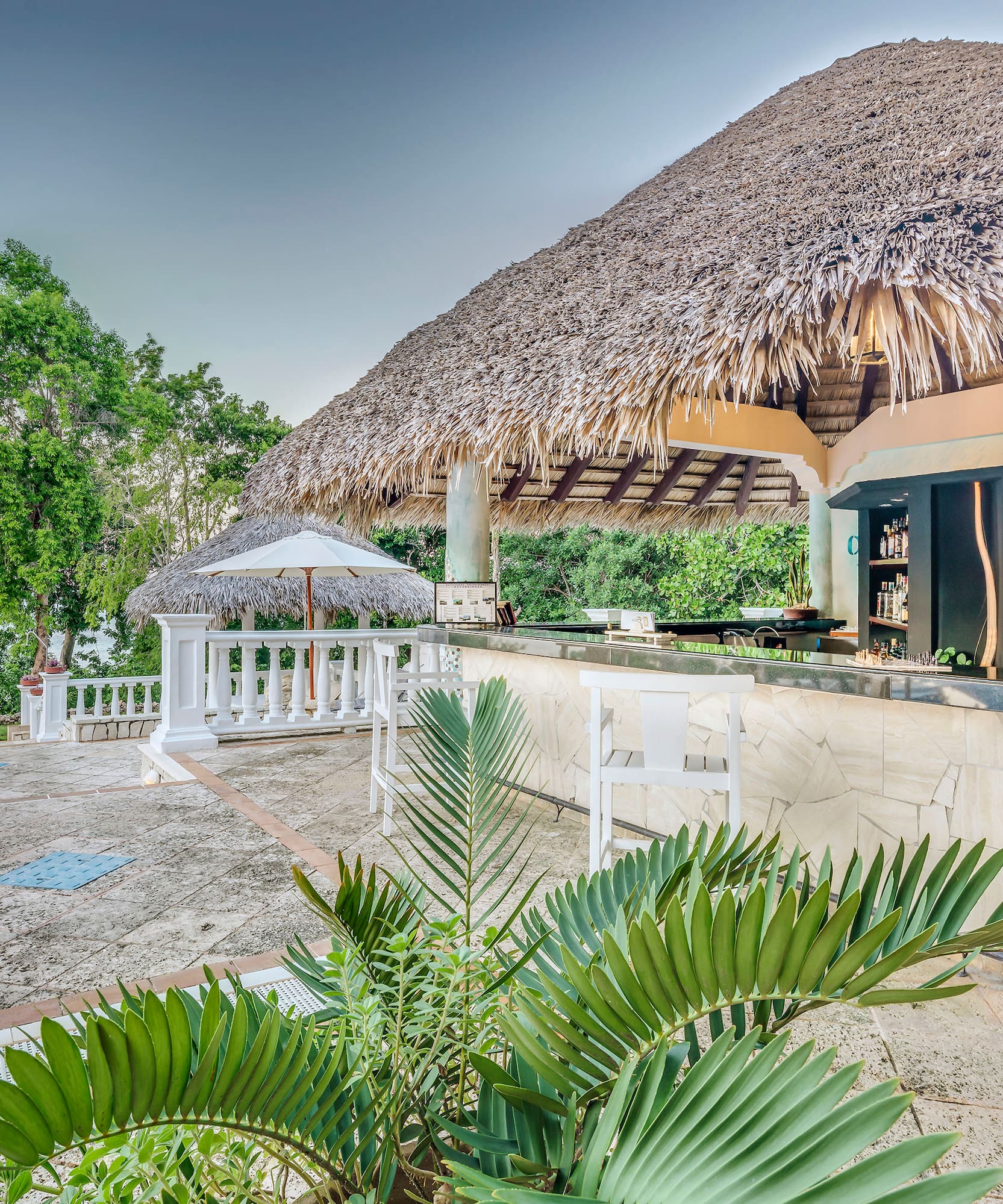 a bar with a straw roof and umbrellas