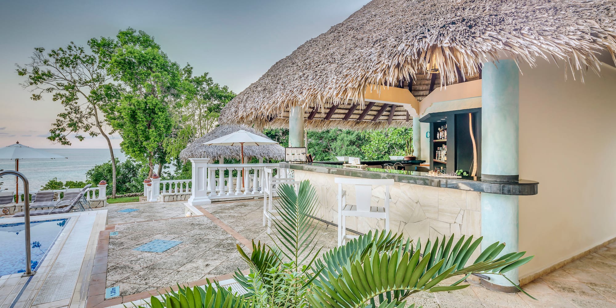 a bar with a straw roof and umbrellas