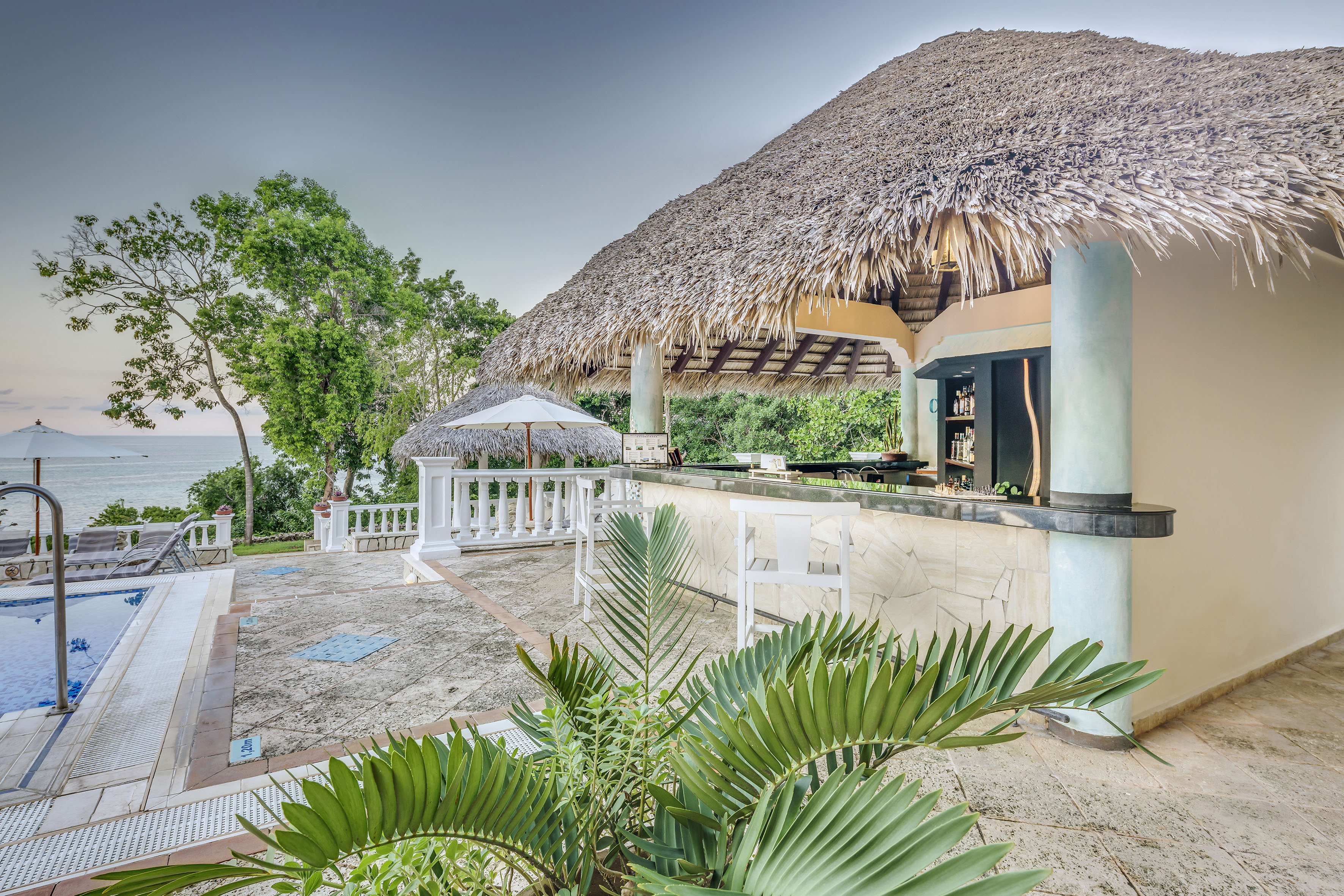 a bar with a straw roof and umbrellas