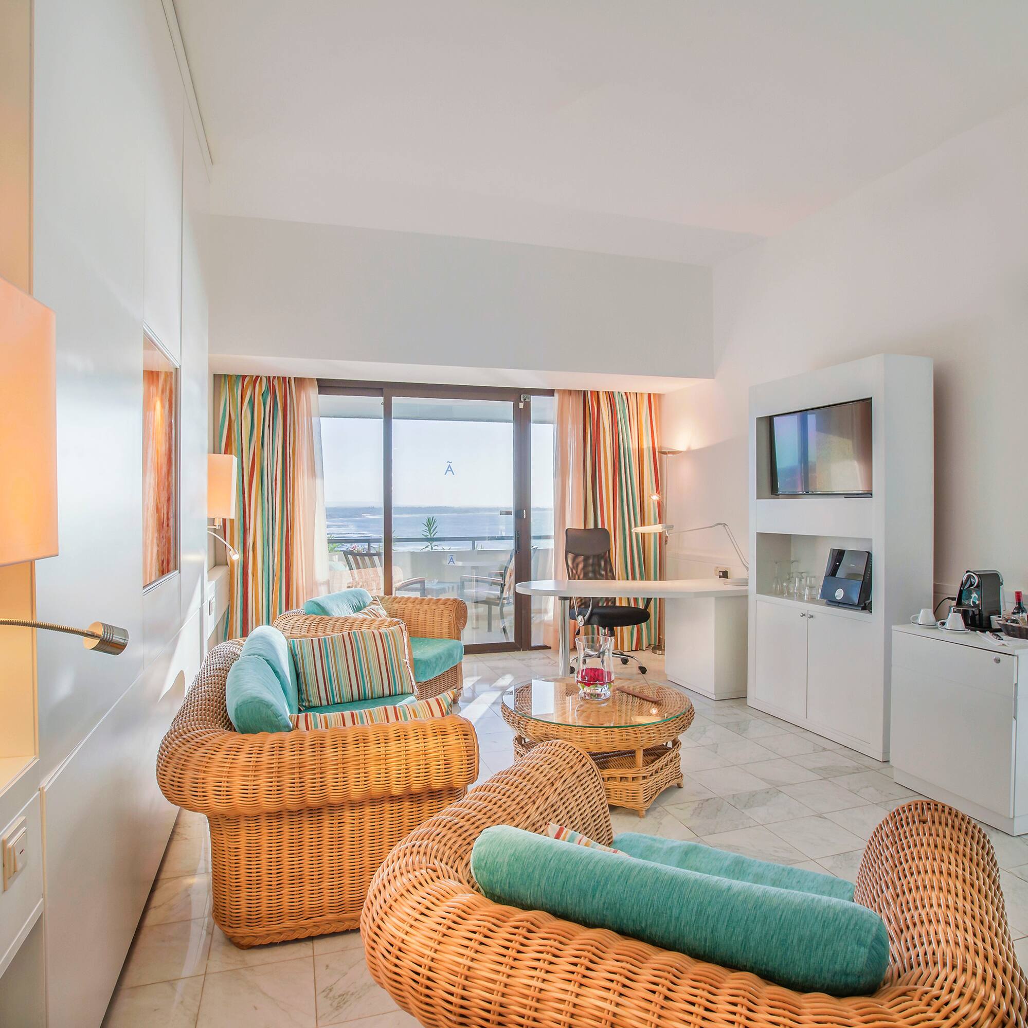 a room with wicker furniture and a television