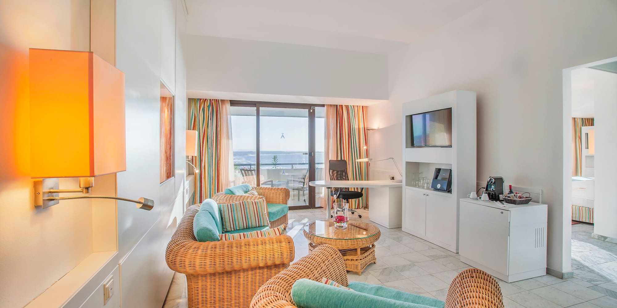 a room with wicker furniture and a television