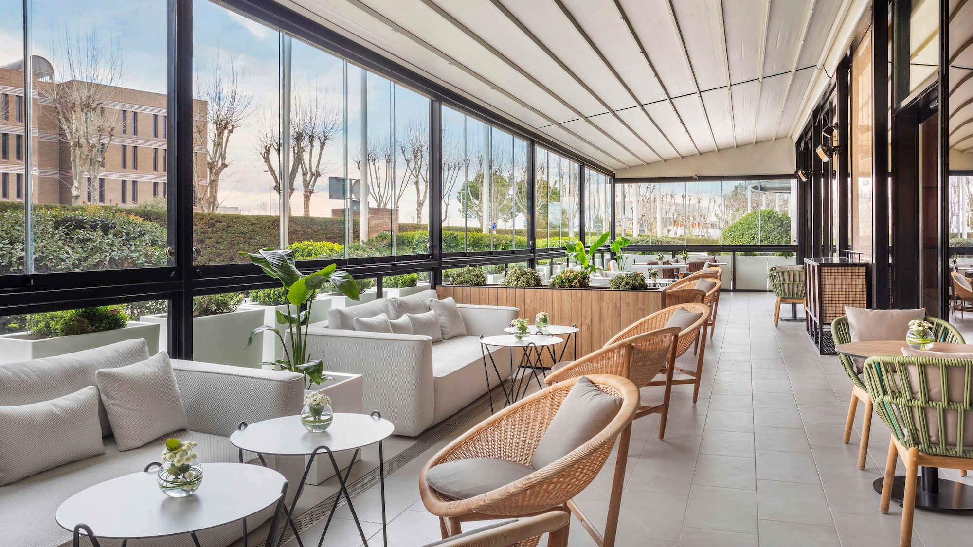 a room with a large glass wall and a white couch and chairs