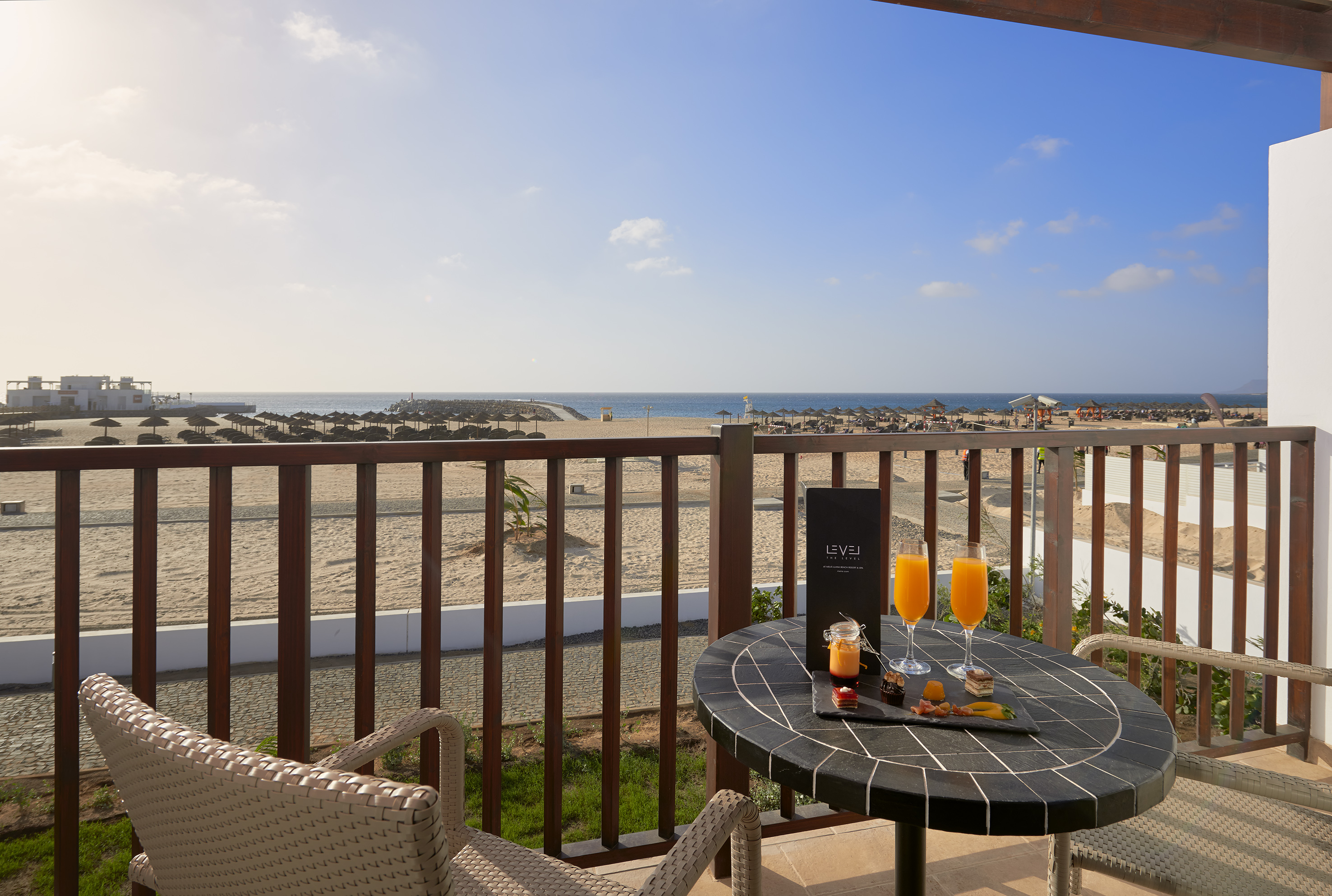 a table with drinks on it and a beach in the background