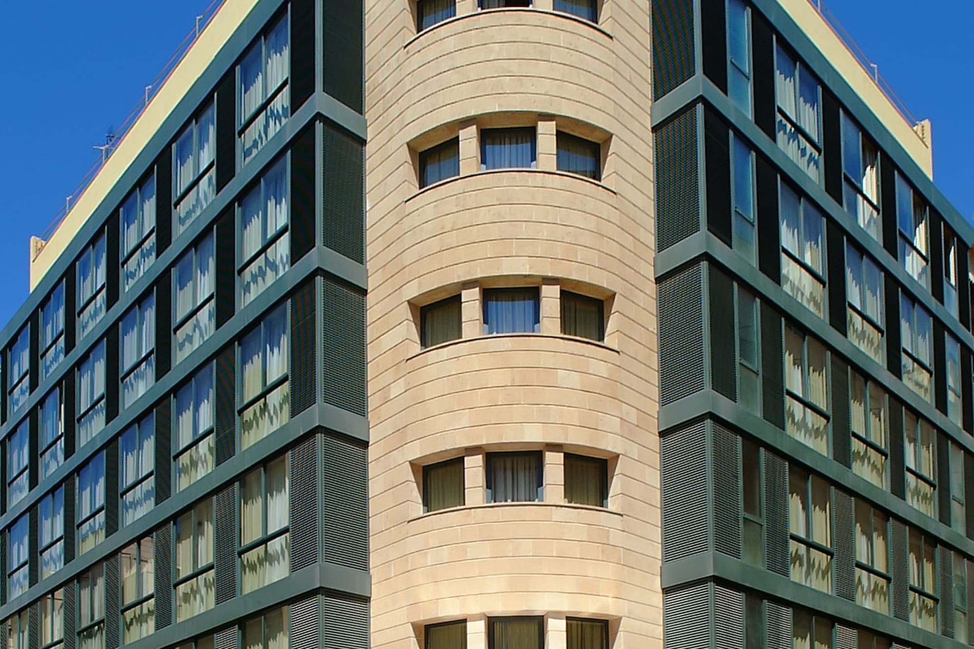 Modern INNSIDE Palma Center hotel, curved stone and dark glass facade.