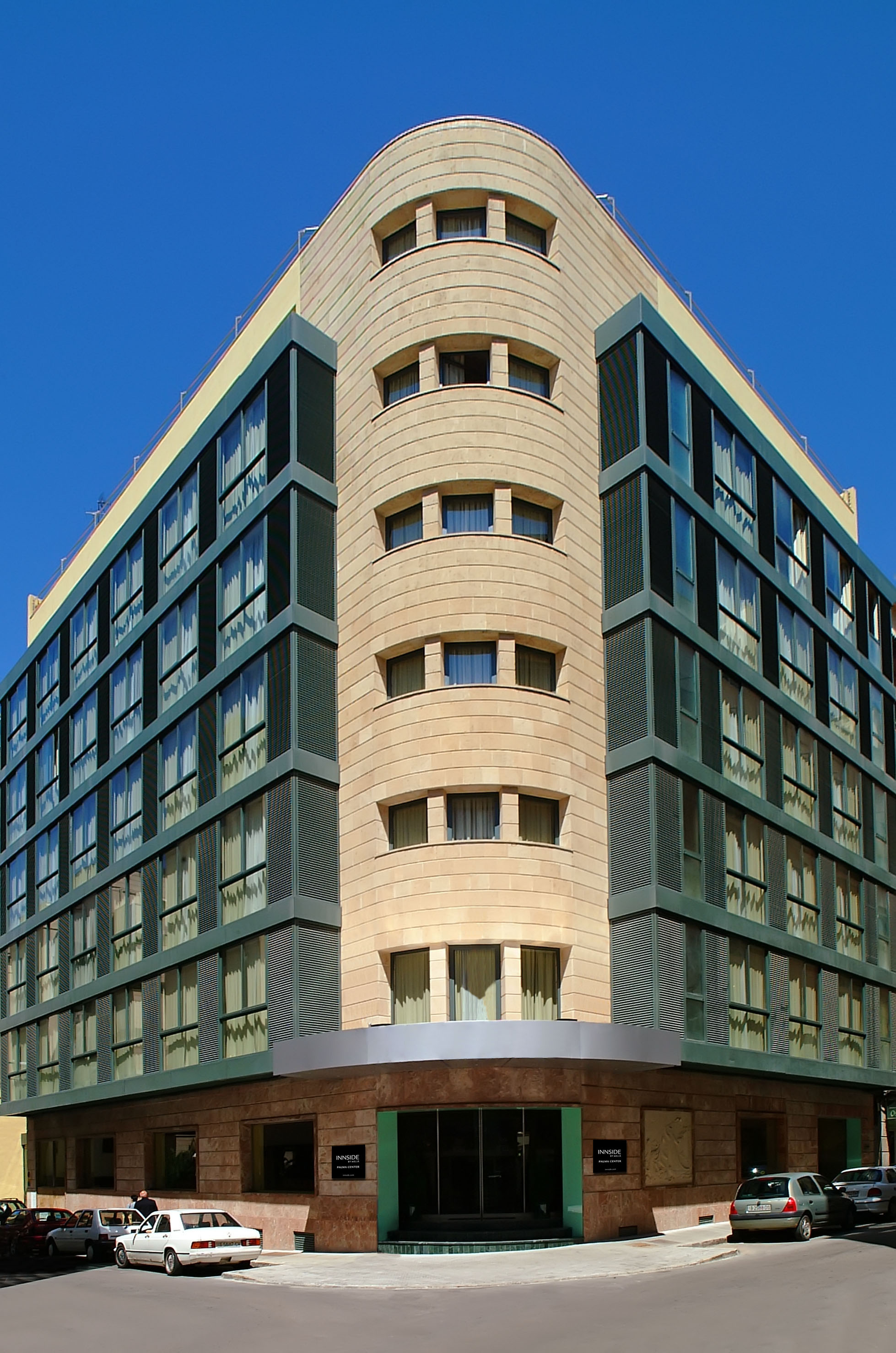 Modern INNSIDE Palma Center hotel, curved stone and dark glass facade.
