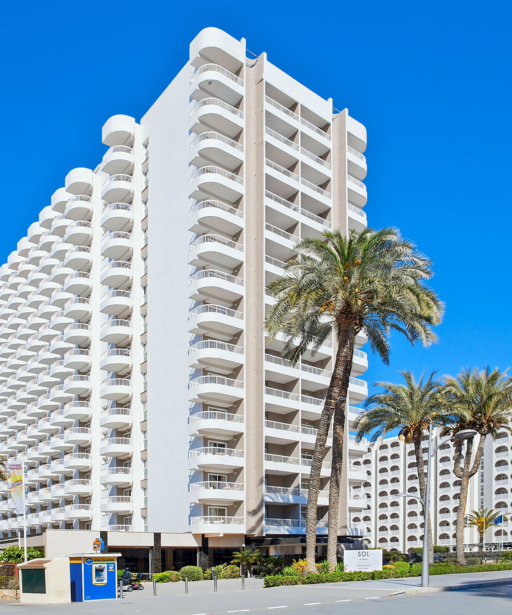 a large white building with palm trees