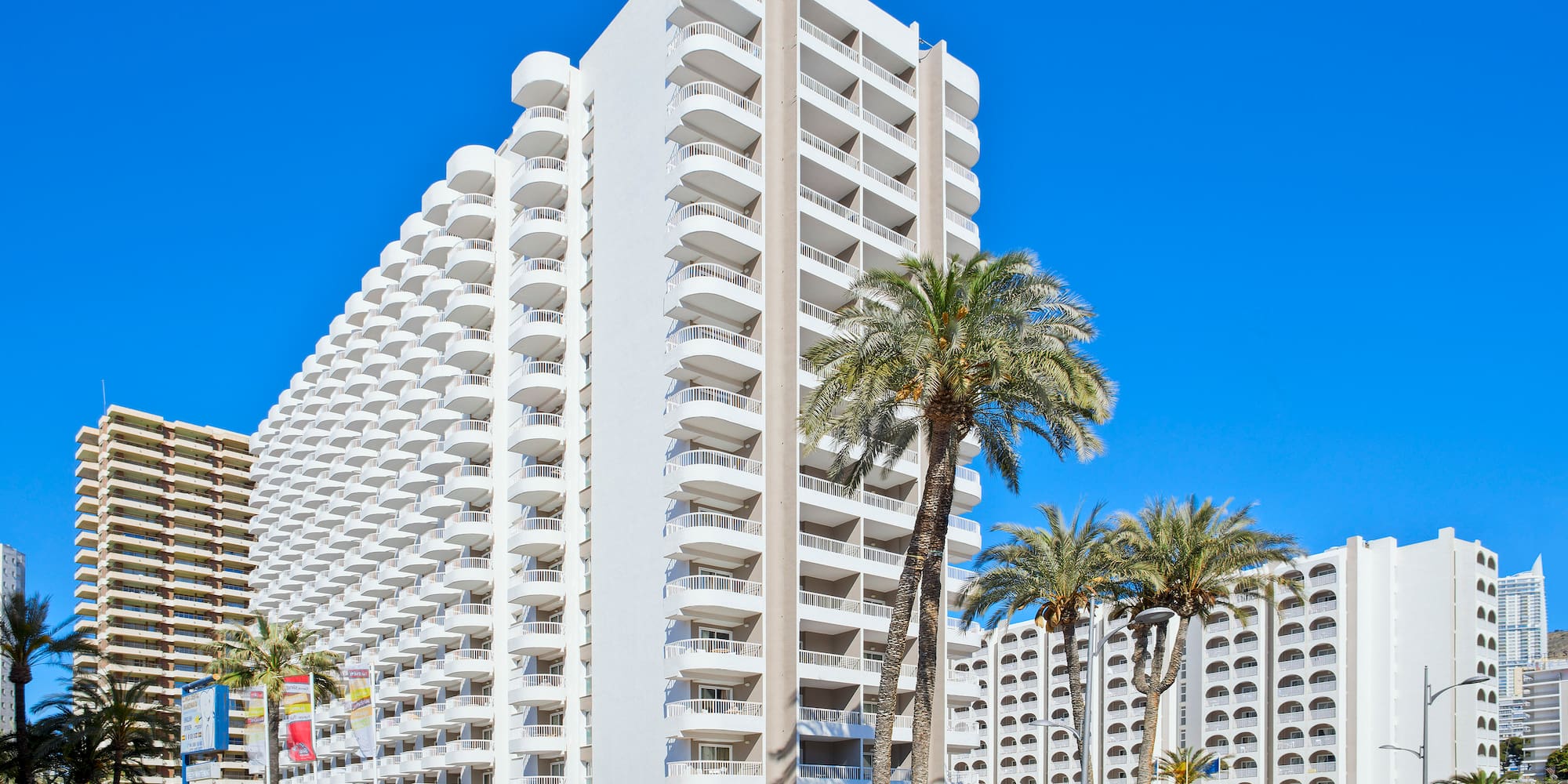a large white building with palm trees