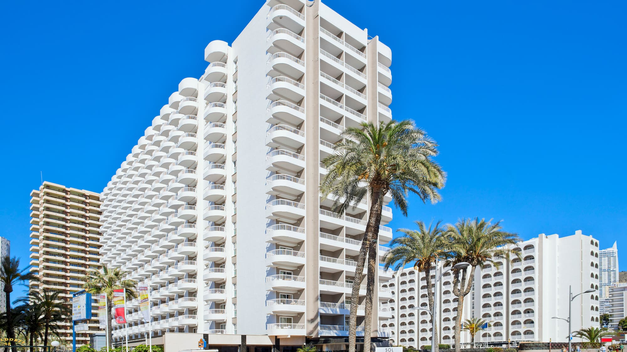 a large white building with palm trees