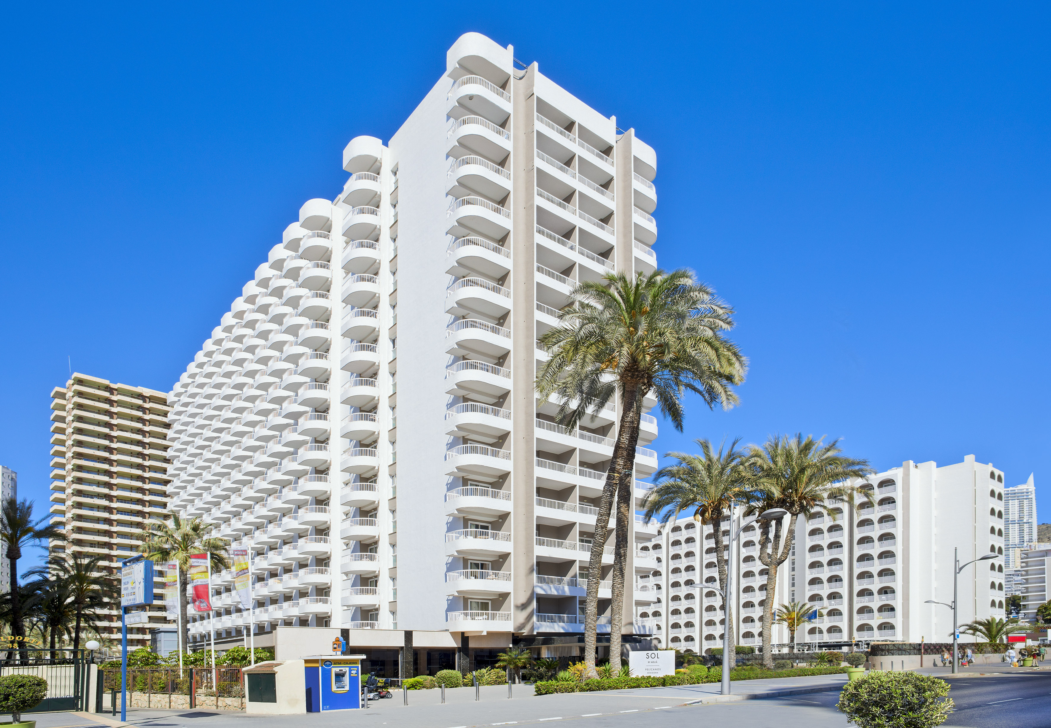 Sol by Meliá hotel, a large white resort with many balconies and palm trees.