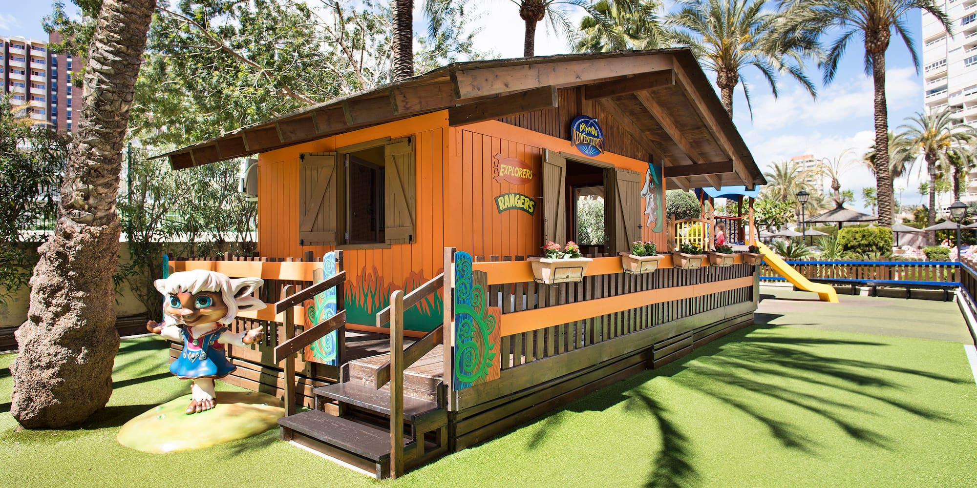 a small building with a slide and a playground