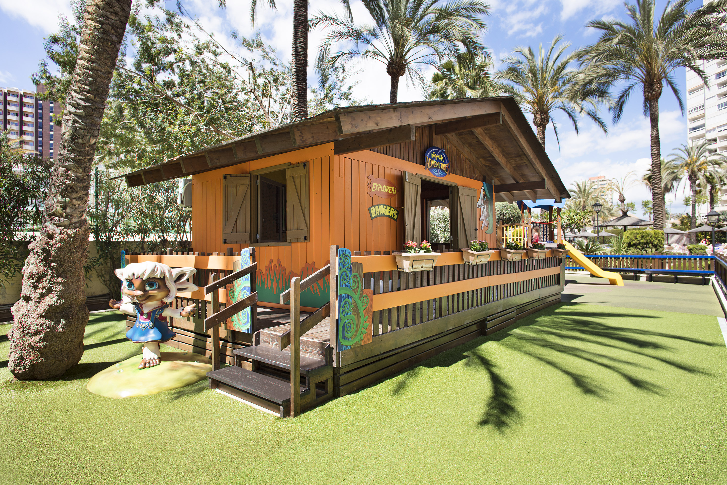a small building with a slide and a playground