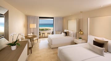 a room with two beds and a table and chairs