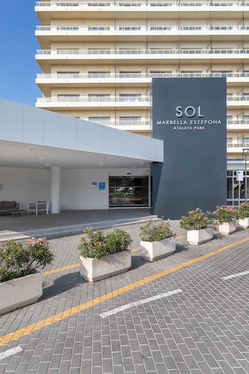 a building with a sign and flowers in front of it