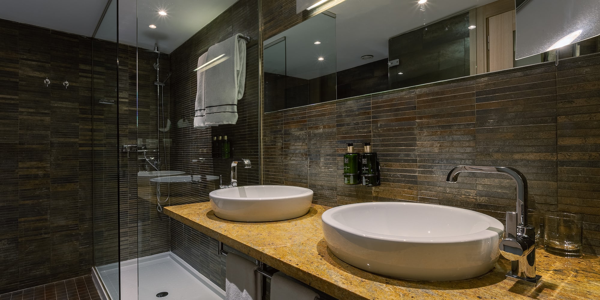 a bathroom with two sinks and a shower