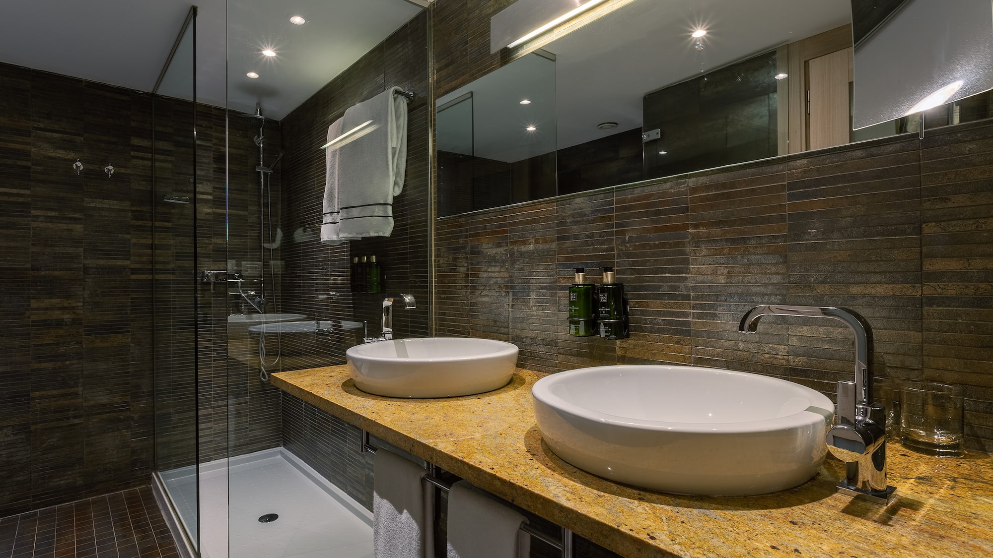 a bathroom with two sinks and a shower