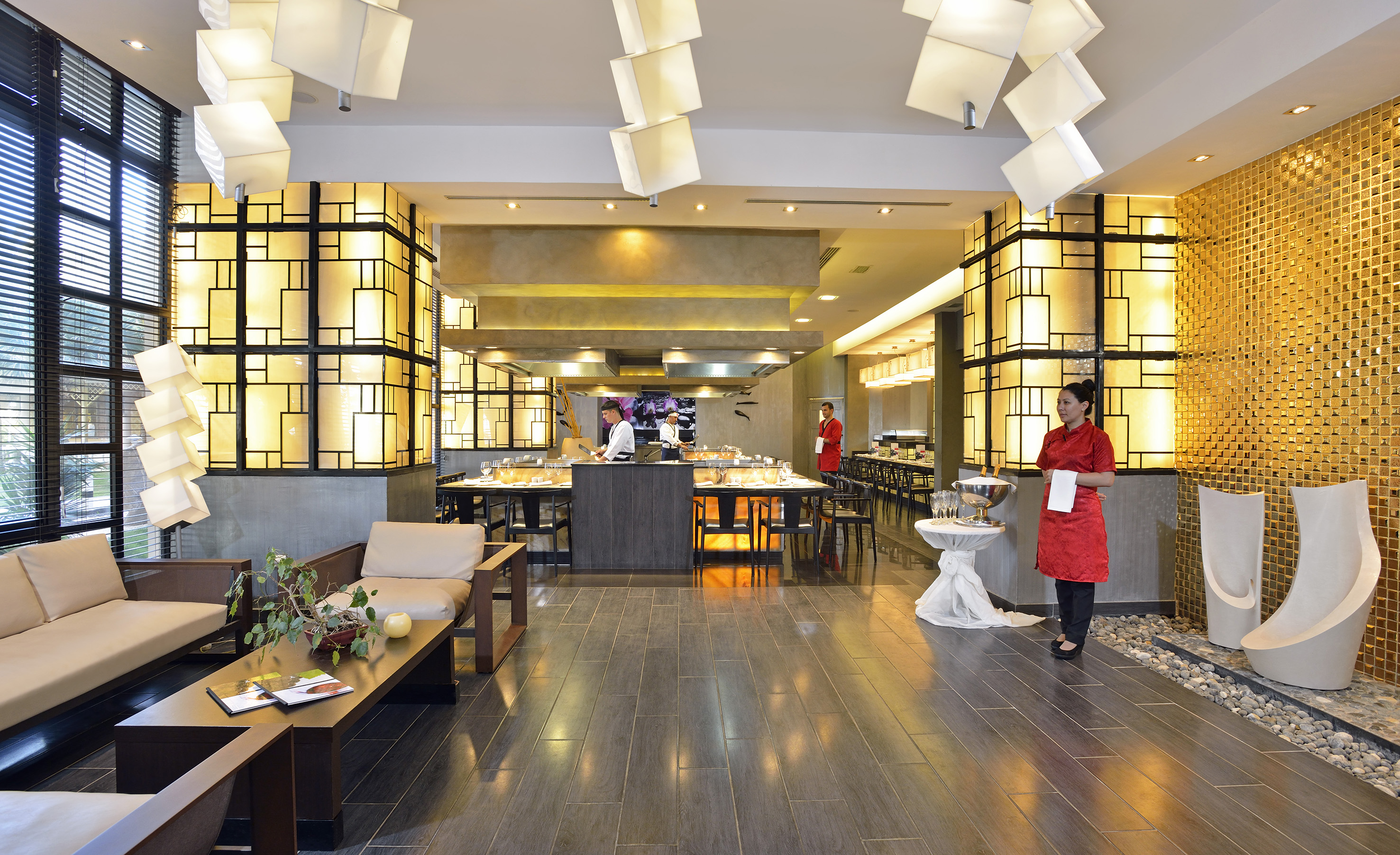 a restaurant with a woman standing in front of a buffet