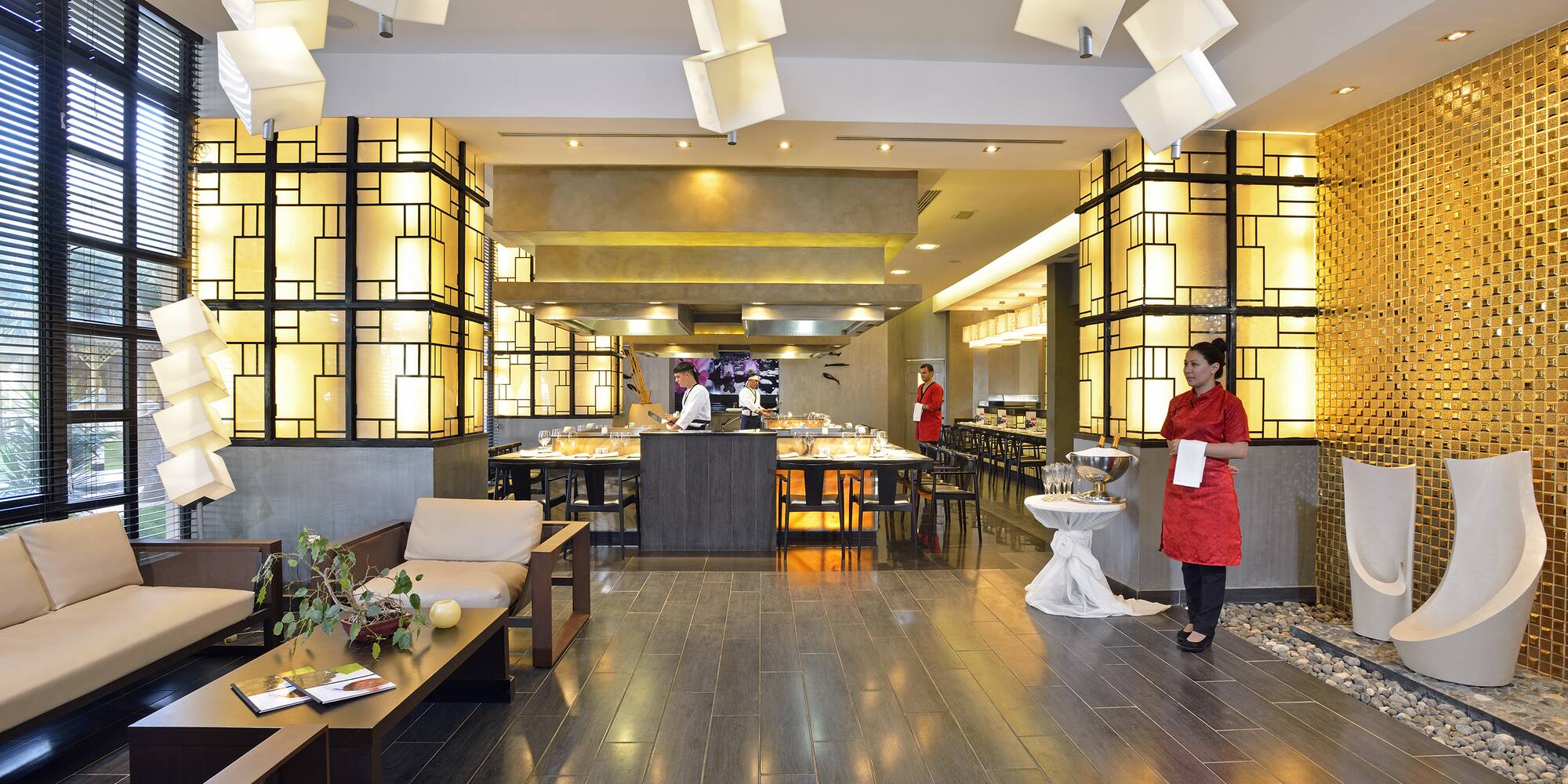 a restaurant with a woman standing in front of a buffet