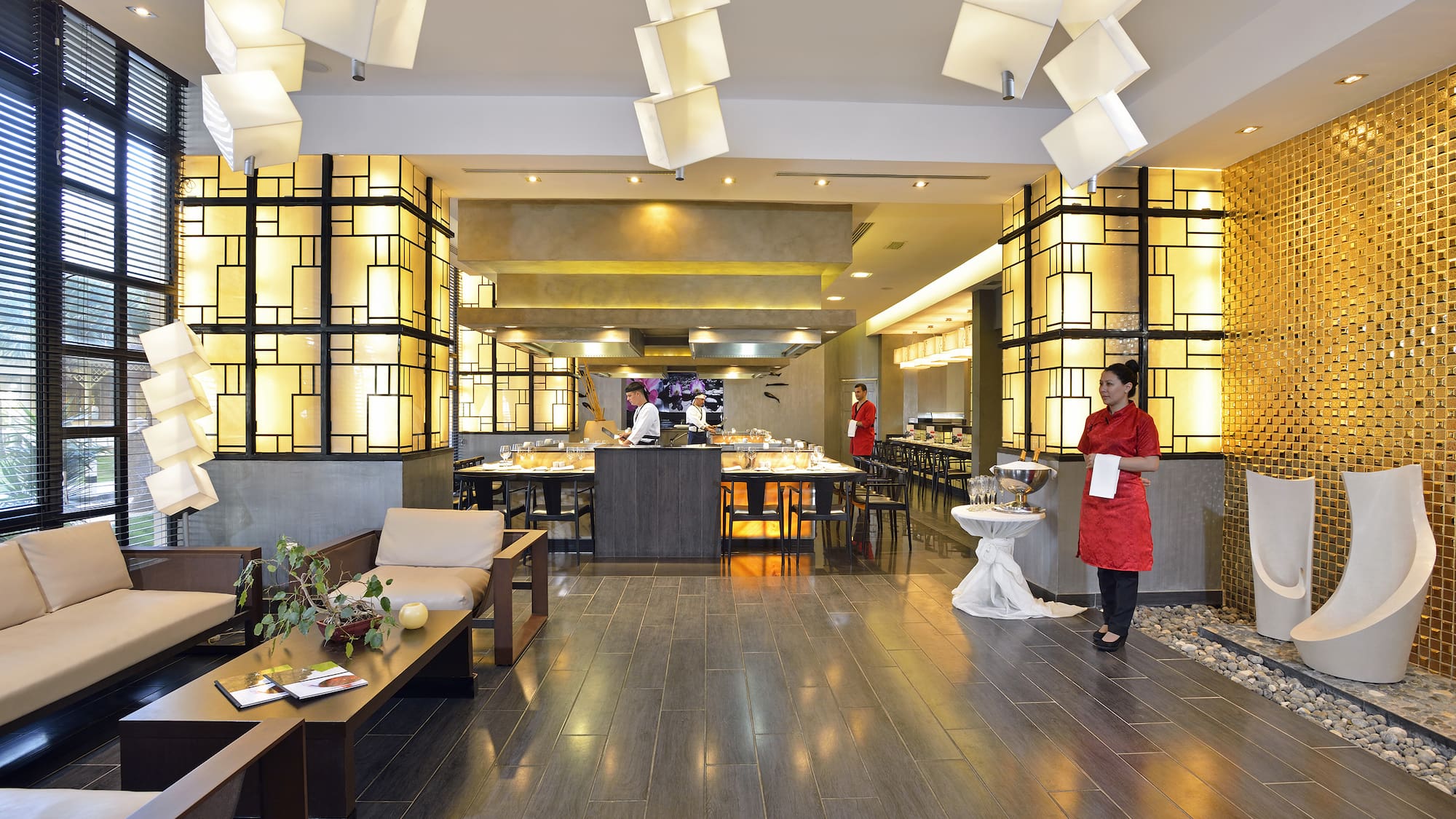 a restaurant with a woman standing in front of a buffet