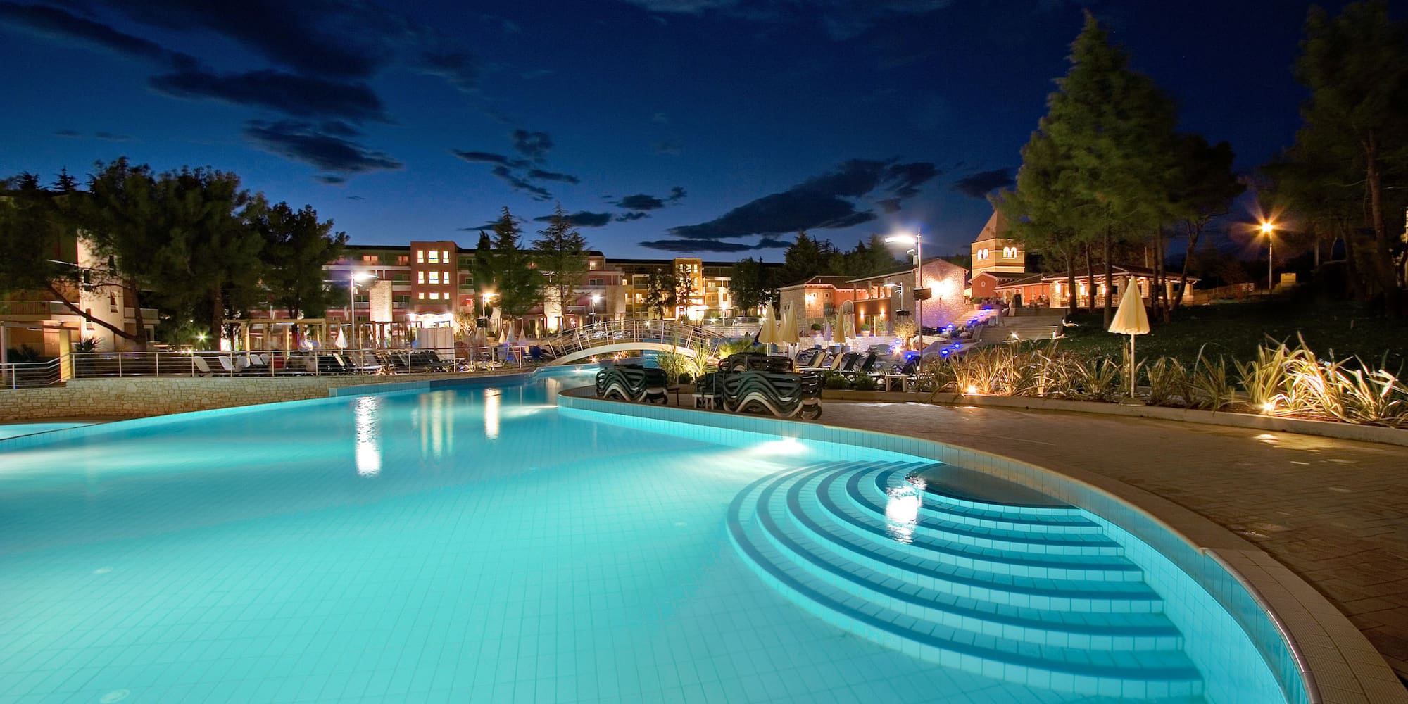 a pool with steps and a building in the background