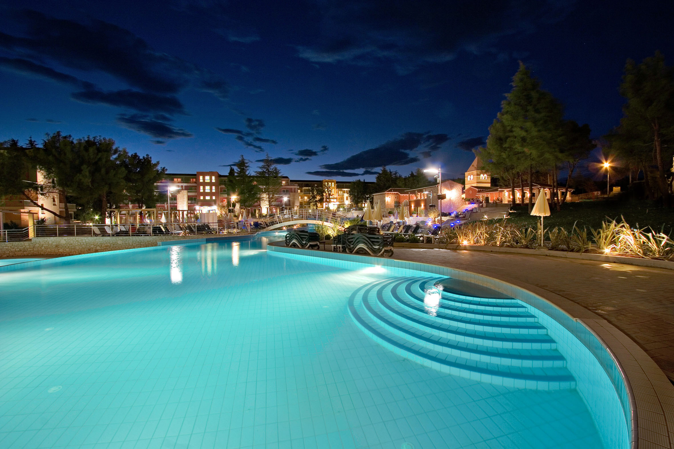 a pool with steps and a building in the background
