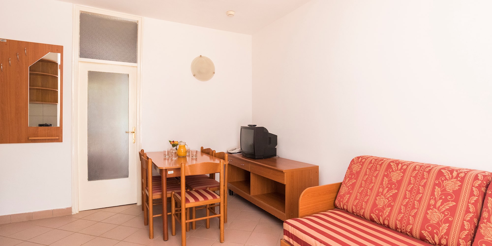 a room with a couch and table and chairs