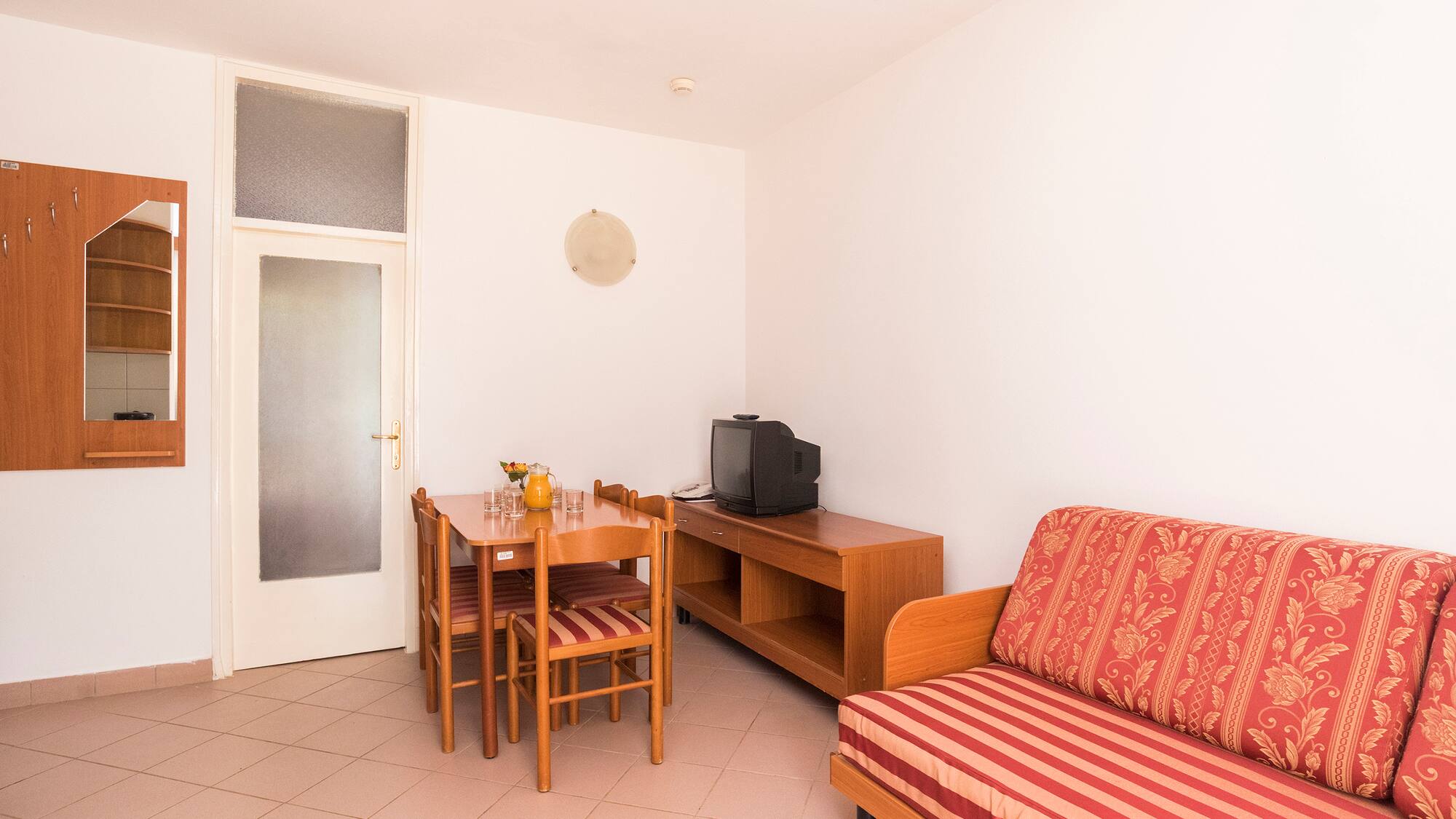 a room with a couch and table and chairs