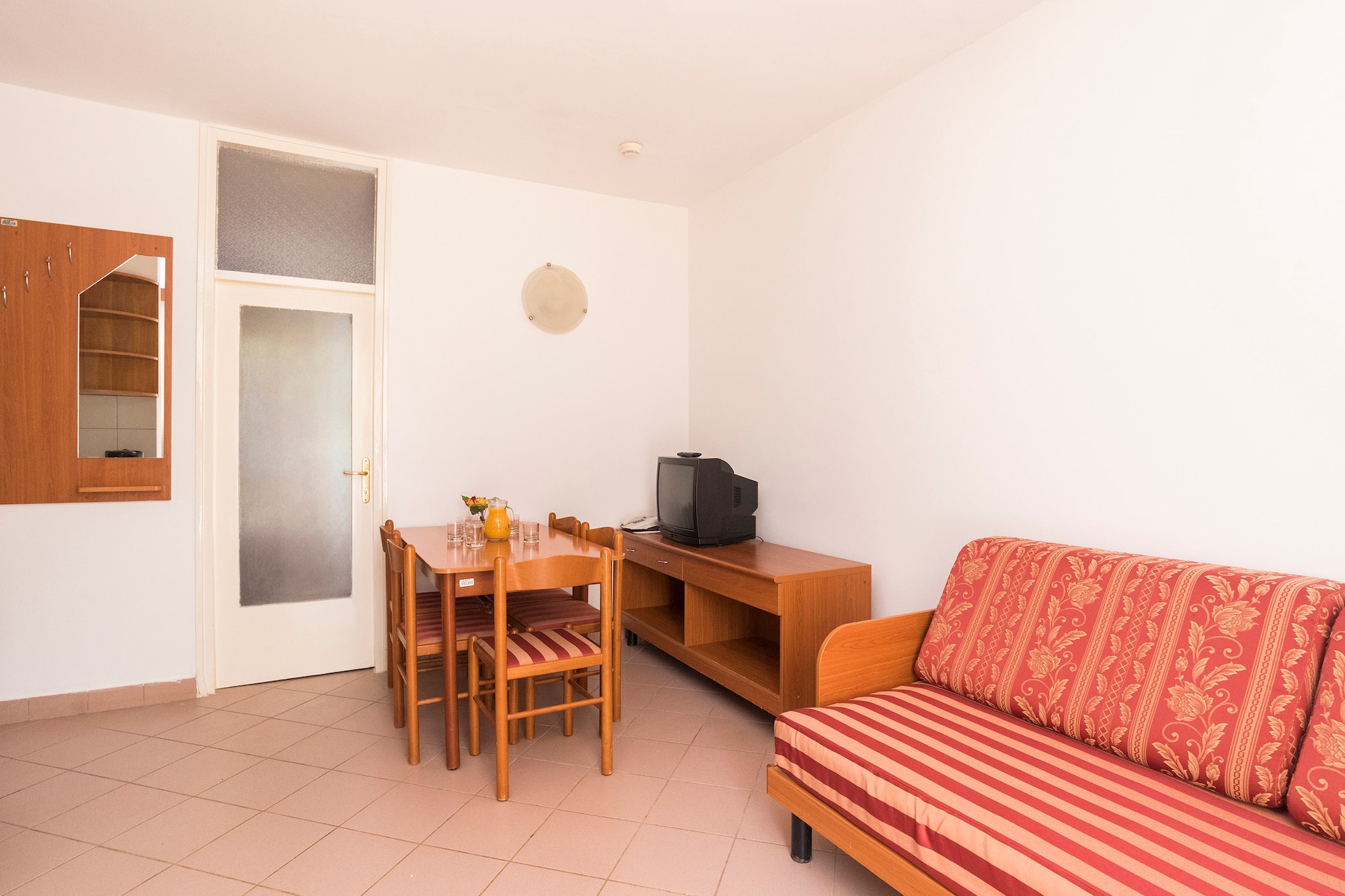 a room with a couch and table and chairs