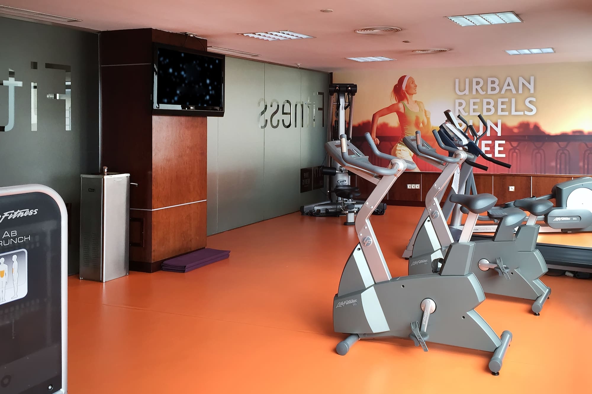 a room with exercise bikes and a tv