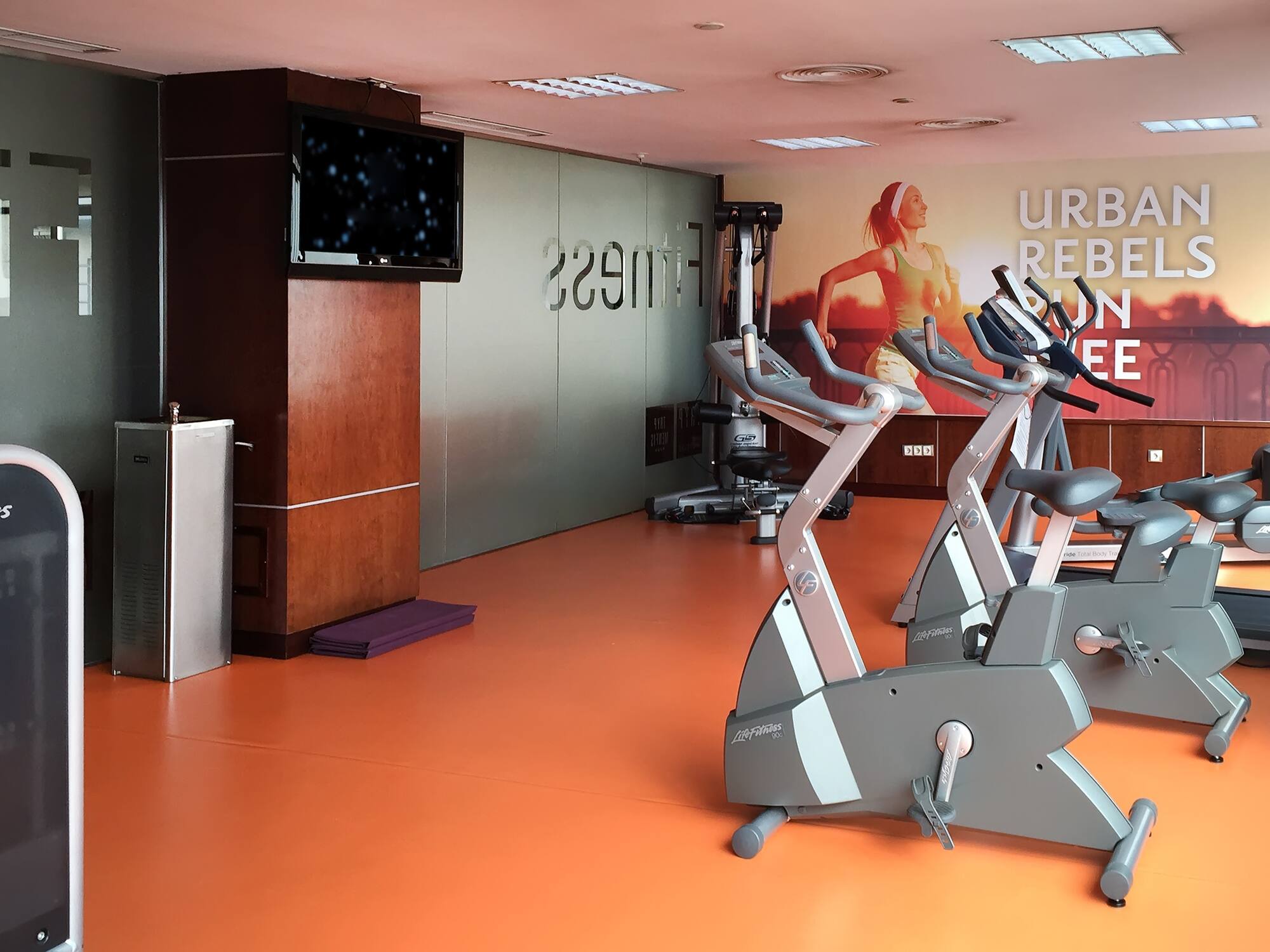 a room with exercise bikes and a tv