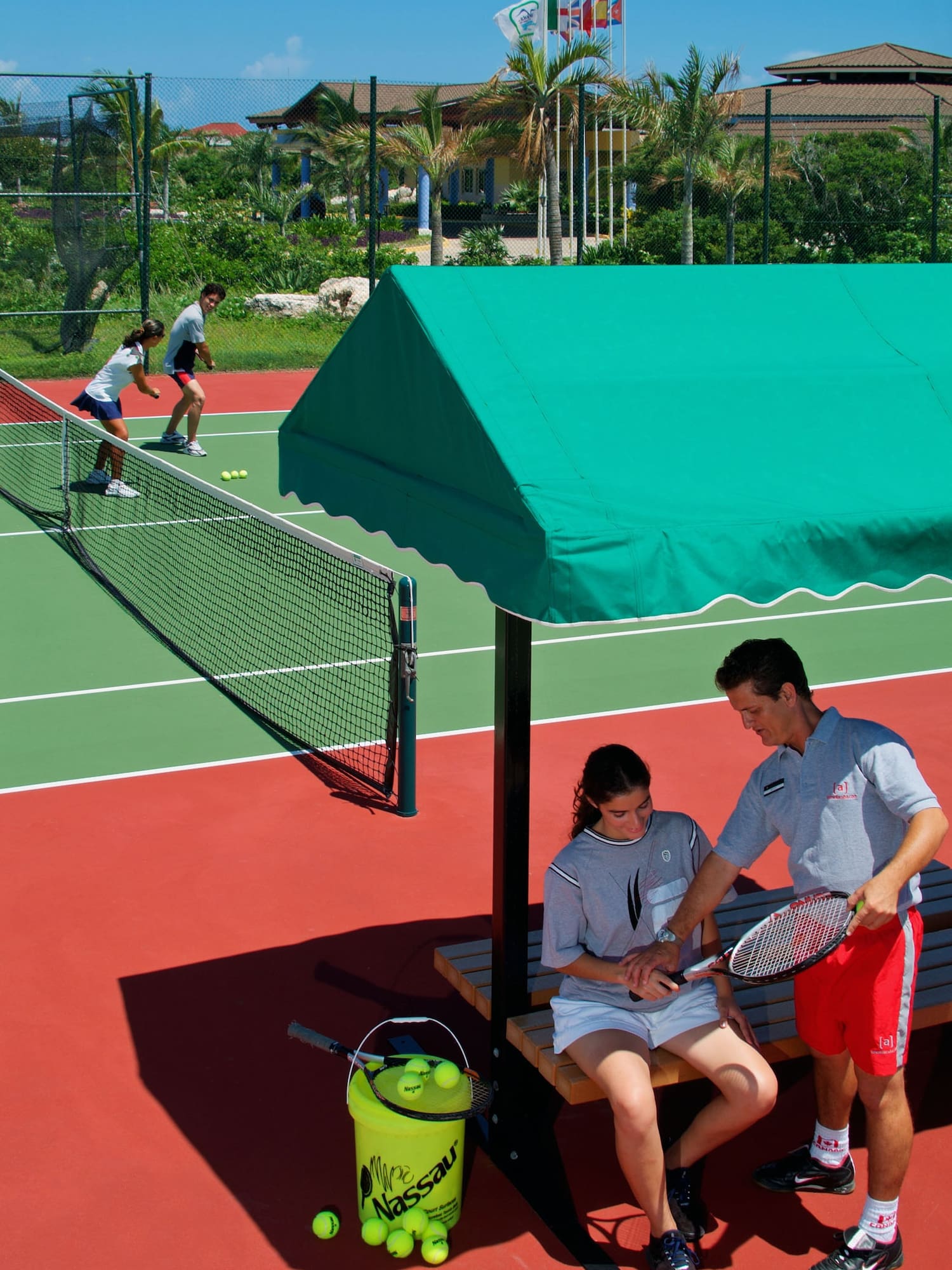 a man and woman sitting on a bench on a tennis court
